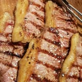 Costillas y cortes marcados a la parrilla sobre tabla de madera